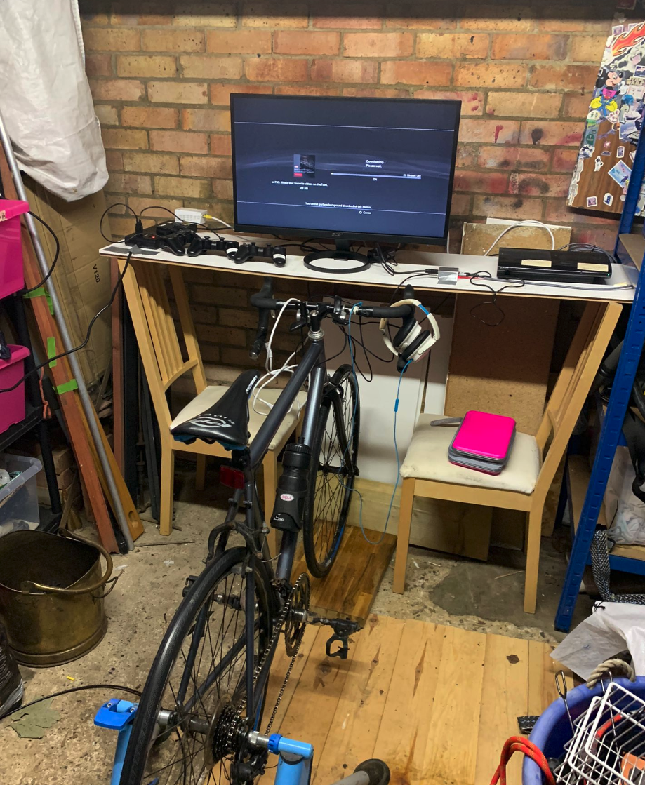 exercise bike in front of ps3 setup that is balanced on two chairs