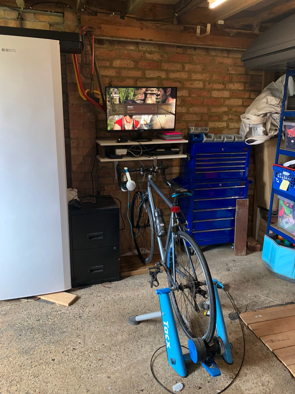 Exercise bike in front of some permanent shelves with a ps3 on them