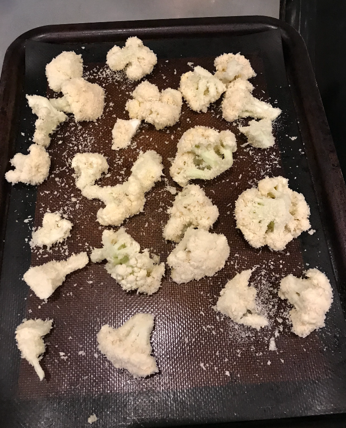 A baking tray with breaded cauliflower on it